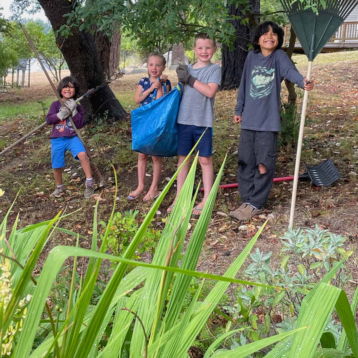 Three kids proud of their work of cleaning a landscape