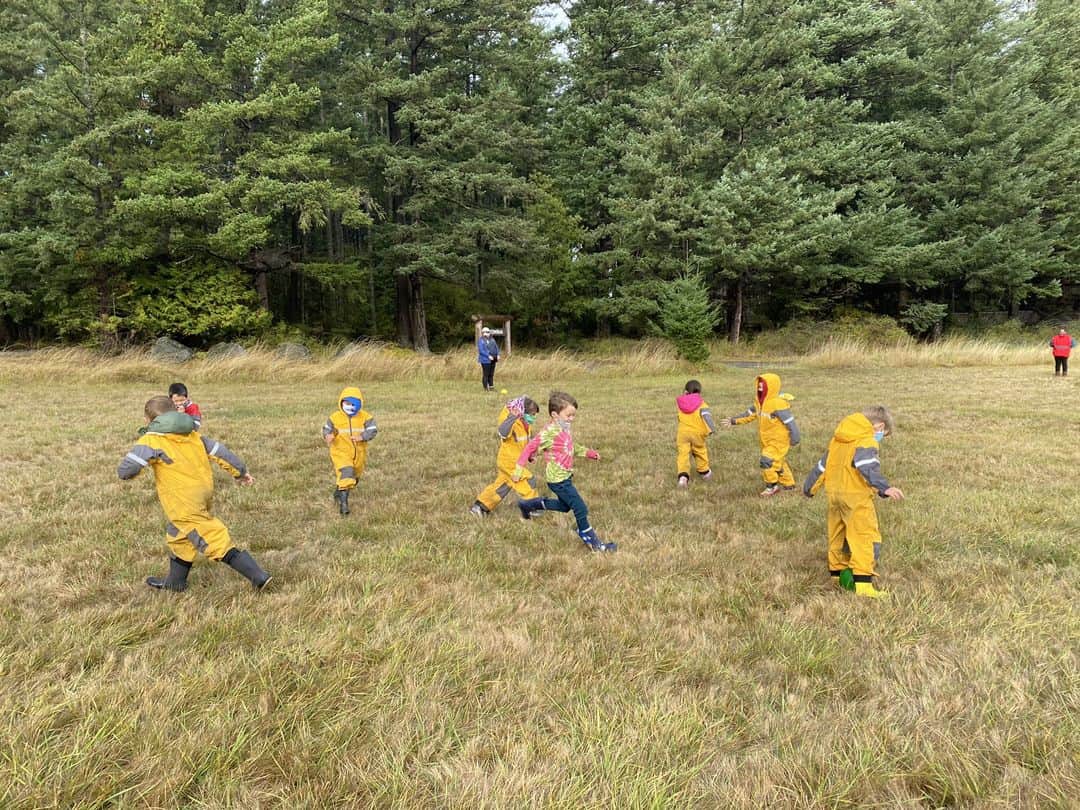 outdoor ed 4 Young kids running around in a field with confirm inn the background